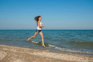 Young girl runs on the sea photo