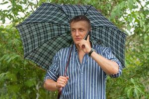 Man with umbrella and mobile phone photo