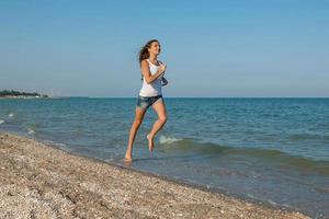 Young girl runs on the sea photo