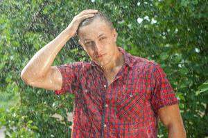 Sexy young man wet in rain photo