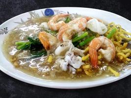 Thai food Fried noodle and crispy rice with Seafood in dish, top view asian cuisine with isolated on background photo
