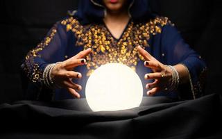 Fortune teller hands with crystal ball photo