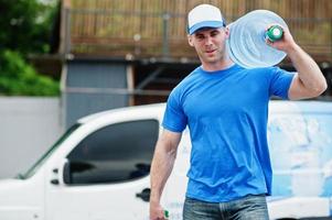 Delivery men in front cargo van delivering bottles of water. photo