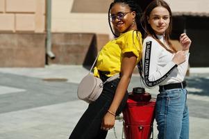 White caucasian girl and black African American together near fire hydrant. World unity, racial love, understanding in tolerance and races diversity cooperation. photo