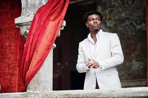 Thoughtful young handsome african american gentleman in formalwear. Black stylish model man in white jacket. photo