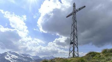 Zeitraffer auf einem Berg mit einem Kreuz mit sich bewegenden Wolken