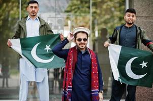 Group of pakistani man wearing traditional clothes salwar kameez or kurta with Pakistan flags. photo