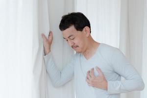 a man touching his heart, with red highlight of heart attack, and others heart disease concept, Heart attack symptom photo