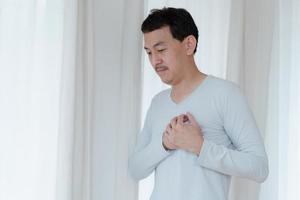 a man touching his heart, with red highlight of heart attack, and others heart disease concept, Heart attack symptom photo