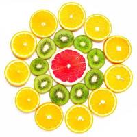 citrus slice, kiwi, oranges and grapefruits in shape of flower on white background. Fruits backdrop photo