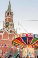 Moscow, Rusisia, 2018 - Spasskaya tower of Kremlin and Merry-go-round carousel on Red Square photo