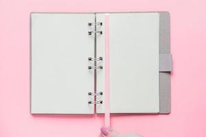 Top view of open empty notebook with cover from recycled paper on pastel pink colorful background photo