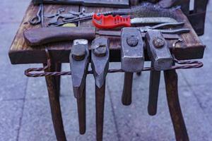 Working metal tools in blacksmith's workshop, close-up, selective focus, toned photo