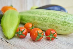 close up of freshly pickled harvest of vegetbles - bell pepper, drill and tomatoes on wooden table. Rustic style. Organic healthy food concept with copy space photo