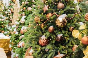 close up of christmas trees decorated with sparkling balls and garland with lights on. Festive background with copy space for your projects photo