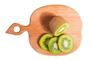 Top view of wooden cutting board with sliced kiwi isolated on white background photo