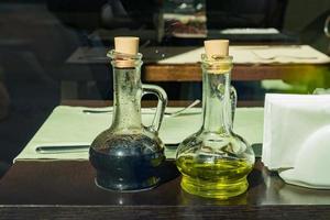 aceite de oliva y vinagre balsámico servidos en una mesa de madera en el café foto