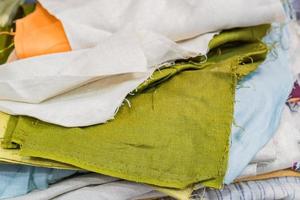 Stack of natural fabrics and textiles  lie at a market stand. Sewing industry concept photo