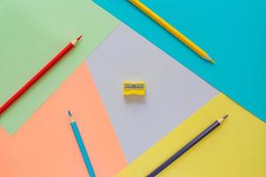 Creative flat lay with school suppllies. multicolored pencils and sharpener on pastel colorful  background. Back to school. photo