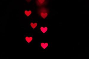 corazón bokeh fondo, amor y concepto de día de san valentín. corazones rojos brillantes luz foto