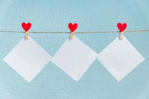 Blank cards on pins with red hearts. Mockup for text and blue background for Valentines Day greetings photo