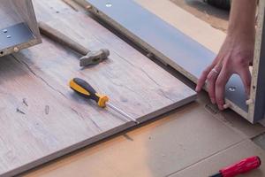 furniture assembling - Carpentry screws for a knock down wooden table. photo