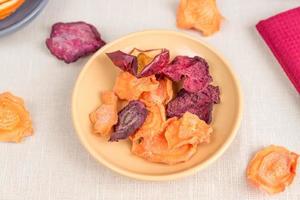 Healthy food organic nutrition. Sliced and dried apple, orange, carrot and beetroot  on textile background. photo