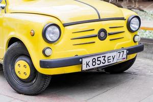 Moscow, Russia, 2018 - Close up of Yellow retro car with round headlights, ZAZ 965 in Izmailovo remlin. photo