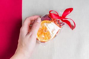 Healthy food organic nutrition. Sliced and dried apple, orange, carrot and beetroot in gift package in female hand on textile background. photo