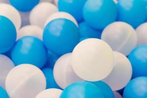 Close up of plastic white and blue balls in dry pool on the playground photo