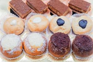 Pastry shop display window with variety of mini desserts and cakes, selective focus photo