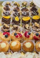 Pastry shop display window with variety of mini desserts and cakes, selective focus photo