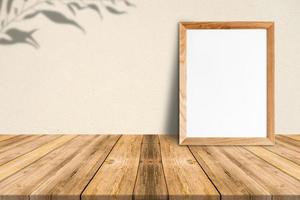 marco de madera en blanco sobre piso de madera tropical y pared de papel beige, maqueta de plantilla para agregar su contenido foto
