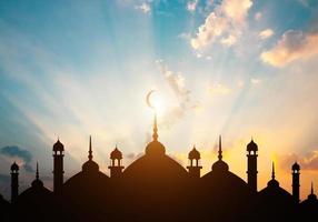 cúpula de mezquitas en el cielo crepuscular azul oscuro y media luna en el fondo, símbolo de la religión islámica ramadán y espacio libre para texto árabe, eid al-adha, eid al-fitr, mubarak, año nuevo islámico muharram foto