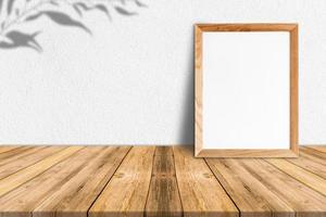 marco de madera en blanco sobre piso de madera tropical y pared de papel blanco, maqueta de plantilla para agregar su contenido foto