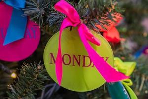 fondo de vacaciones de navidad y año nuevo. árbol de navidad decorado con bola roja y letras de lunes. concepto de celebración foto