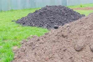 Black soil piles in the backyard for gardening photo