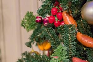 Christmas and New Year holidays background.  Christmas tree decorated with artificial sausagws, tomatoes and balls photo