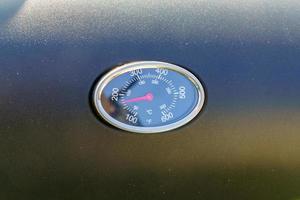 Close-up of the thermometer on the grill shows the temperature. photo