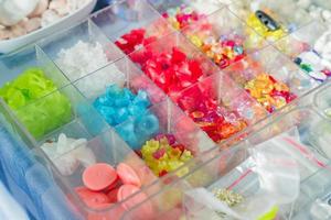 colorida mezcla de perlas de vidrio. variedad de formas y colores para hacer collares o pulseras. materiales de bricolaje foto