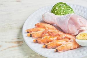 concepto de dieta cetogénica baja en carbohidratos en un plato. alimentación saludable y dieta con gambas, aguacate, huevos y sésamo. foto