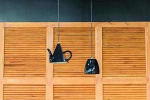 kitchen interior decoration. Lanterns in shape of kettle and cup on wooden panel wall background photo