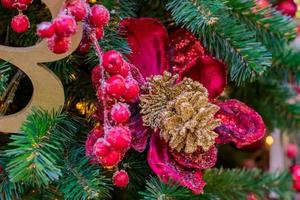 fondo de vacaciones de navidad y año nuevo. árbol de navidad decorado con bolas y bayas rojas heladas. concepto de celebración foto