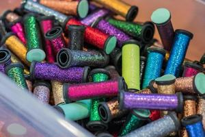 rolls with metallic threads in plastic container  in assortment for craft photo
