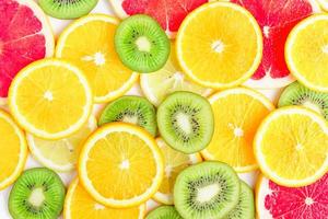 citrus slices - kiwi, oranges and grapefruits on white background. Fruits backdrop photo