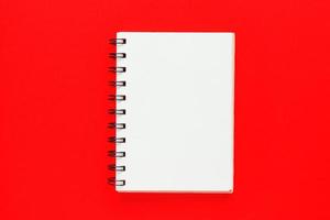 Top view of open empty notebook on bright red colorful background photo