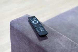 TV remote contoller lying on the coach photo