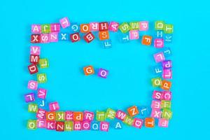 GO inscription made of colorful cube beads with letters. Festive blue background concept with copy space photo