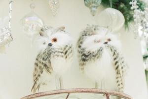 Two white snowy owls on a brach. Interior decoration.