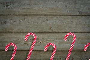 Traditional Christmas candy canes on wooden background. photo